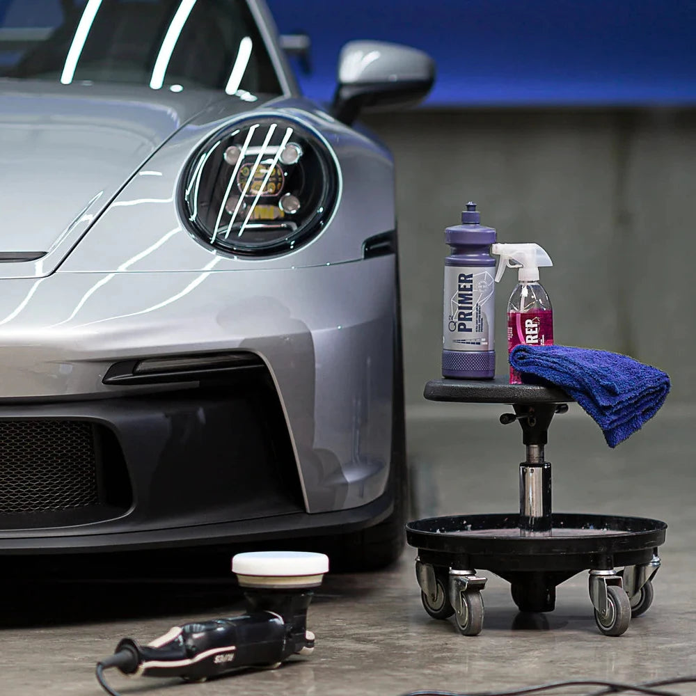 Car detailing setup with a car, cleaning tools, and products on a stand in studio in Atlanta Marietta Georgia